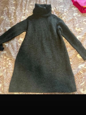 Mörkgrå polotröja från ONLY - Säljer en lång, mörkgrå polotröja från ONLY i mjukt stickat material. Tröjan har hög polokrage och soprena linjer, perfekt för lager på lager under kyliga dagar. Långärmad och är fin till jeans. 