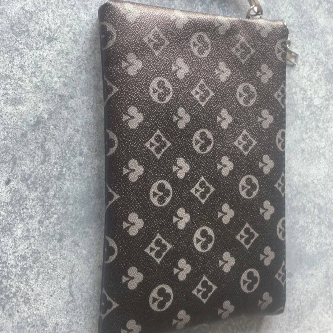 Svart kuvertväska med monogrammönster