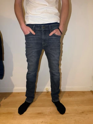 Mörkblå jeans från Jack & Jones - Snygga mörkblå jeans från Jack & Jones Jeans Intelligence med klassisk femficksdesign och raka ben. Jeansen har normal passform och är tillverkade i slitstarkt bomullsmaterial med snygga detaljer och kontrastsömmar. Perfekta för dig som gillar stilrena och bekväma jeans.