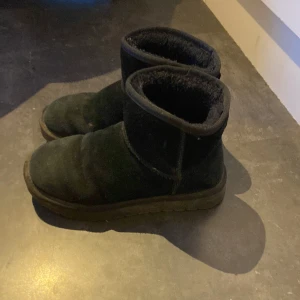 Svarta boots i mocka med foder - Mysiga svarta boots i mocka med mjukt foder på insidan och grov sula. Skorna har rund tå och platt sula, perfekta för kalla dagar. Klassisk design som funkar till det mesta och håller fötterna varma hela vintern.