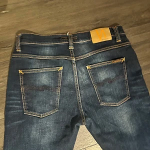 Mörkblå jeans från Nudie - Snygga mörkblå jeans från Nudie. De har inga defekter och är använda 2 gånger, skriv vid frågor. Priset är inte hugget i sten och kan diskuteras via snabb affär 