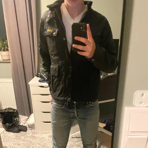 Quiltad Barbour jacka - Säljer en svart quiltad Barbour jacka i storlek XL i barn, den är väldigt lite använd men har en liten fläck på insidan. Annars är den i väldigt fint skick. Jag på bilden är 170cm och den är lite liten. Skulle säga att den passar någon mellan 150-165cm beroende på hur man vill att den ska sitta.  Kom pm vid frågor. Pris kan diskuteras. 