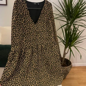 Leopardmönstrad klänning  - Leopardmönstrad klänning  med v-ringning och lång ärm. Klänningen har en lös passform och faller fint, klänningen är helt ny och inte använt💛
