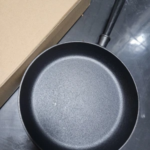 Vinga gjutjärnspanna - Robust gjutjärnspanna från Vinga med klassisk design och trähandtag med mässingsdetalj. Pannan är i mycket gott skick utan synligt slitage, perfekt för stekning och lång hållbarhet. Passar alla typer av spisar, inklusive induktion.