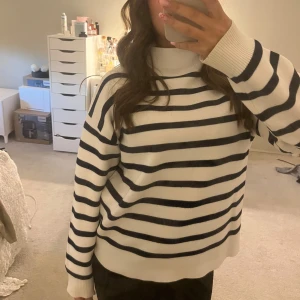 Stickad tröja - Mysig stickad tröja med hög krage och mörkblåa ränder🤍använd ett fåtal gånger!