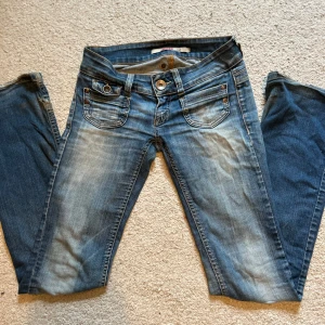 bootcut jeans från Only - Snygga blå bootcut jeans från Only med ljusare partier framtill. Klassisk femficksmodell med LÅG midja och detaljerade nitar vid fickorna. Ganska slitna nedtill men inget man riktigt tänker på. Passar mig i längden som är typ 168cm💕. PS: köp gärna via instabox, postar snabbare då (inom 24h)🥰