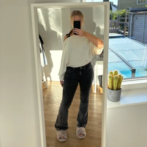 Grå bootcut jeans - Grå bootcut jeans från Gina tricot i storlek 36. Har en fläck vid sidan av ena låret, eftersom jeansen är lite gråmelerade är det inget som stör jättemycket. 