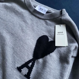 Ami Paris Tröja -  Ami Paris tröja    Storlek: S  Skick: Helt ny med prislapp kvar  Färg: Grå med klassiska Ami de Cœur-loggan   perfekt för både vardag och lite finare tillfällen   📦 Kommer i toppskick, redo att användas direkt. 🚚 Skickas snabbt.  