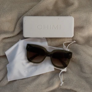 Mörkgröna CHIMI solglasögon - Snygga solglasögon från CHIMI med mörkgröna, tjocka bågar i en cool, kantig form i modellen 08. 😍 Linserna är tonade i brunt och bågarna är tillverkade i blank syntet. Kommer med originalväska och putsduk med CHIMI-logga. 💚