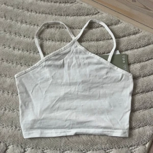 Vit linnetopp från H&M - Ett enkelt och fräscht linne. Helt oanvänt, lappen sitter kvar 