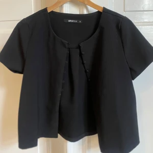 Svart blus med knappar  - Svart tröja, man kan både ha den som en kofta eller bara som den är! Pris kan diskuteras!