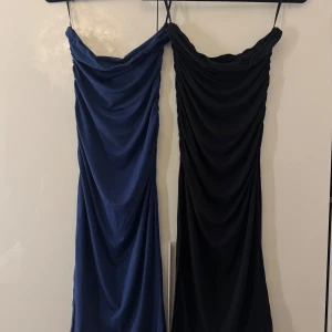 Svart och blå klänning med slits - Två stilrena medel långa klänningar i svart och blått. Båda har en snygg slits på sidan och är figurnära med ett mjukt, stretchigt tyg som faller snyggt. 