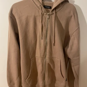Beige hoodie från Jack & Jones - Säljer en beige hoodie från Jack & Jones med dragkedja framtill, huva med snörning och stora fickor. 