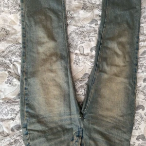 Blå jeans straight fit från 157 - Ett par klassiska blå jeans från 157 med raka ben och knäppning med knappar. Jeansen har en lätt tvättad look och normal passform. Perfekta för dig som gillar en enkel och tidlös stil. Materialet är robust denim i bomull.