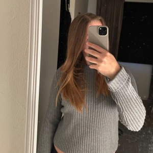 Grå ribbad stickad tröja - Säljer en grå ribbad stickad tröja med lång ärm och rund hals. Från pull and bear 