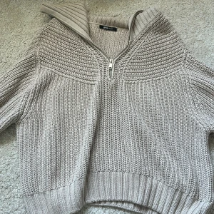 Beige stickad half zip-tröja Gina Tricot - Säljer en beige stickad tröja från Gina Tricot med half zip-dragkedja och hög krage. Tröjan har grovstickad struktur, ribbade muddar och en relaxed passform. den är i storlek m men passar även om du är en s eller xs och vill ha den lite oversized, köpte den för 2 år sen för 349 men knappt använd