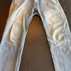 Levi's 551 ljusblå jeans W32 L32 - Ljusblå Levi's 551 jeans med klassisk femficksdesign och raka ben. Jeansen har en snygg tvättad look och är tillverkade i slitstarkt bomullsjeans. Perfekta för dig som gillar en avslappnad och tidlös stil.