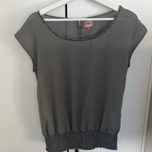 Grå blus från ONLY - Säljer en stilren grå blus från ONLY med rund halsringning. Bra skick☺️