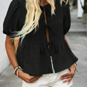 Blues med knyten och puffärmar - Säljer nu min svarta topp/blues jag haft ett tag men knappt kommit till användning. Den sitter precis som på bilden och kom dma för egna bilder! Är i väldigt bra skick och ett bekvämt material. Nypris 160kr💗