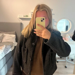 Svart kappa - Säljer en svart, kort kappa med stora knappar framtill och två rejäla fickor. Jackan har en boxig passform och är perfekt för dig som gillar en stilren och enkel look. Passar till både jeans och kjol och är superenkel att matcha. Den är lite nopprig och har använts, pris kan diskuteras🥰