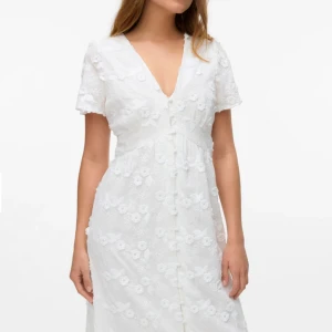 Vit långklänning med broderade blommor - Vit klänning från vero Moda i storlek XS. Aldrig använd. Passar perfekt till studnet eller liknande 