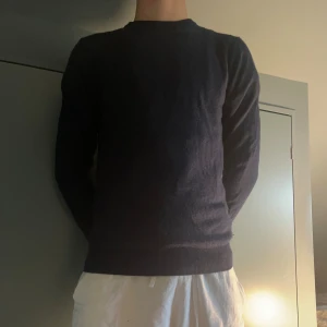 Mörkblå kashmirtröja från John Henric - Nypris 2299kr! Priset Ej Hugget i sten! En liten defekt men annars inget alls. Lite Knottrig på bild men inget som inte går bort i tvätt. Snygg mörkblå tröja i mjuk kashmir från John Henric. Klassisk rund hals och ribbade muddar vid ärmslut och nederkant. Perfekt för dig som gillar stilrena och bekväma plagg med premiumkänsla. Passar dig som vill ha en enkel men lyxig look.