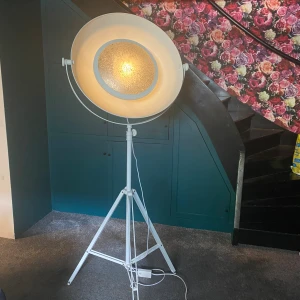 furninova Golvlampa med vitt stativ och rund skä - Golvlampa med vitt metallstativ och rund, vit lampskärm. Lampan är utrustad med en glödlampa och har en strömbrytare på sladden. Passar för inomhusbruk och kan användas som allmänbelysning eller arbetsbelysning. furninovas