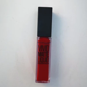 Maybelline Vivid Matte Liquid Rebel Red - Flytande läppstift från Maybelline i färgen 35 Rebel Red. Intensivt röd nyans med matt finish. Kommer i en stilren, fyrkantig plastförpackning med svart lock. Perfekt för dig som vill ha en djärv och färgstark look.