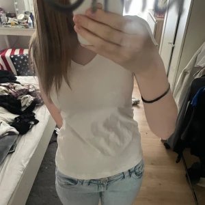 Vit v-ringad t-shirt Basic You XS - Vit t-shirt från Basic You i storlek XS. Modellen är v-ringad med korta ärmar och har en slim passform. Tillverkad i mjuk bomull, perfekt för en clean och enkel stil.