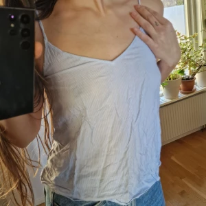 Randig blå linnetopp från H&M Divided - Blå-vit-randig tunn topp med smala axelband. 