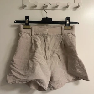  Linne shorts -  Beiga linne shorts med fickor och  dragkedja