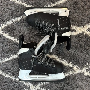 Svarta och vita skridskor Pulse 5 - Snygga svarta och vita skridskor från Pulse 5 med robust design och coola svarta/vita snören. Passar bra nu i för vintern. De är i skridskorstorlek 37 men passar folk upp till skostorlek 40.