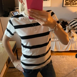 Randig svartvit t-shirt i bomull - Snygg t-shirt med breda svarta och vita ränder. Klassisk passform och rund halsringning. Perfekt till jeans eller shorts för en chill look. Gjord i mjuk bomull som känns skön mot huden.