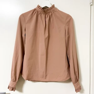 Blus - Beige blus - mjuk, elegant och tidlös. Helt ny och i perfekt skick, aldrig använd Sitter snyggt och passar bäde till vardag och fest. Skick: ny Färg: beige Kan skickas snabbt
