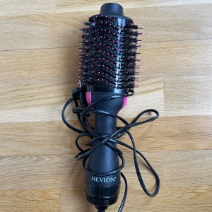 Revlon One-Step Hair Dryer & Volumizer - Revlon One-Step hårfön och volymborste i svart och rosa. Ger snabbt volym och slätar ut håret. Synligt använd, men fungerar bra. Perfekt för enkel styling hemma! 