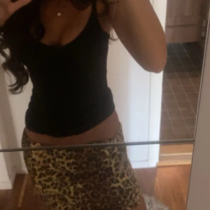 Leopardmönstrad kortkjol - Snygg kortkjol med leopardmönster i bruna och gula toner. Kjolen har en tight passform och är perfekt för dig som vill sticka ut med en trendig look. Passar till både enkla toppar och mer statement-plagg.