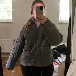 Grå quiltad pufferjacka med dragkedja - Säljer en grå pufferjacka med quiltad design och dragkedja framtill. Jackan har en loose passform, långa ärmar och praktiska fickor. Perfekt för dig som gillar en chill och oversized look. Använd få gånger så i väldigt bra skick, köpt för 859kr💕