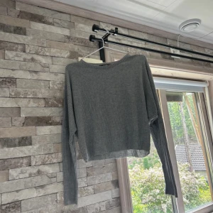Grå ribbad långärmad topp Bik Bok - Säljer en grå ribbad långärmad topp från Bik Bok. Toppen har en croppad passform och är tillverkad i mjukt material som passar perfekt till jeans eller kjol. Enkel och stilren design med rund halsringning.