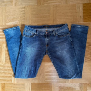 Nudie Jeans - Blåa Nudie Jeans med snygg wash, Storlek 32/34. Modellen är Tight Long John. Sparsamt används.
