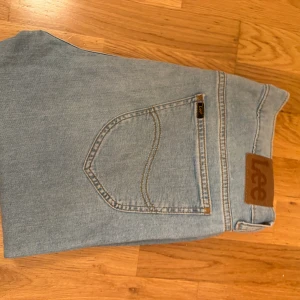 Lee Rider ljusblå jeans W32 L32 - Säljer ett par klassiska Lee Rider jeans i ljusblå tvätt. Jeansen har raka ben, fem fickor och Lee-logga på bakfickan. Tillverkade i bomull med snygga kontrastsömmar och normal passform. Perfekta för en avslappnad och stilren look. Väldigt bra skick köpt från Åhléns för 800kr använt bara en gång!! Pris 349kr 