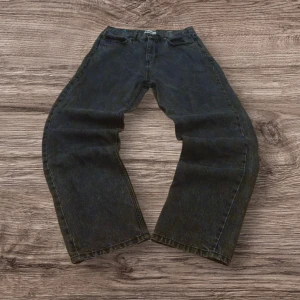 Svarta wide jeans från FSBN 30/32 - Säljer ett par svarta jeans från FSBN i storlek 30/32. Jeansen har en bred, loose passform med raka ben och klassisk femficksdesign. Materialet är robust denim och färgen är tvättad svart med en cool vintagekänsla. Perfekta för dig som gillar avslappnad stil.