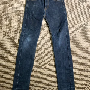 Levi's 510 skinny jeans mörkblå - Mörkblå Levi's 510 skinny jeans med klassiska bakfickor och gul kontrastsöm. Jeansen har en smal passform och är tillverkade i stretchig denim för extra komfort. Perfekta för dig som gillar en tajt look och vill ha ett par stilrena jeans i garderoben.
