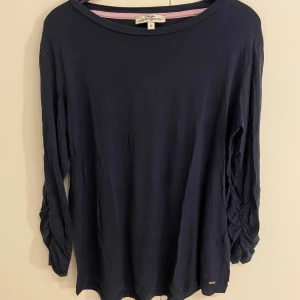Mörkblå långärmad tröja Banana Republic - Mörkblå långärmad tröja från Kappahl med snygga rynkade detaljer längs ärmarna. Tröjan har en rund halsringning och är gjord i mjuk bomull. Jättefin och skön.