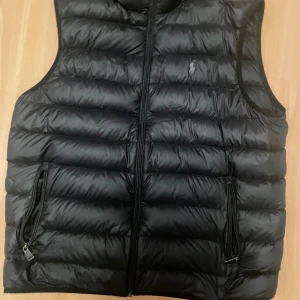 Svart dunväst från Polo Ralph Lauren - Svart dunväst från Polo Ralph Lauren med väldigt bra kvalitet som köptes ny för 5 månader sedan för 2900