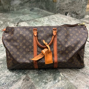 Louis Vuitton keepall - Louis Vuitton  Keepall 50 Datecode: mi874 (1987) 3999:- Skick: Vanchetta läder har spruckit lite och har missfärgat sig Canvas i bra skick! Nametag ingår 