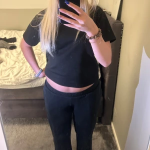 Svarta mjukisbyxor med resårmidja - Svarta mjukisbyxor med skön resår i midjan och raka ben. Perfekta för chill dagar eller när du vill vara bekväm. Sitter löst och har en klassisk look som funkar till det mesta. Materialet känns mjukt och stretchigt.