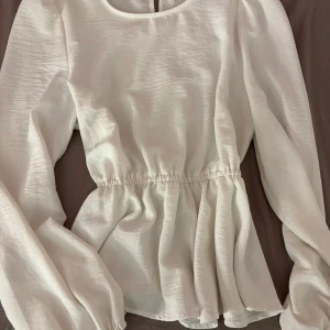 Vit blus med markerad midja - Super söt blus! Strl m men eftersom den har resor i midjan passar den även S/xs