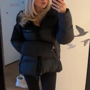 Sail racing jacka - Säljer en svart pufferjacka från sail racing med hög krage och dragkedja framtill. Jackan är vadderad och har en oversized passform som ger en cool och avslappnad look. Perfekt för kalla dagar när du vill vara både varm och snygg. Storlek M men passar S