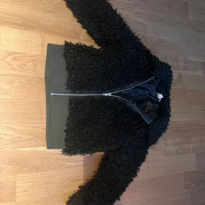 Mörkgrön teddyjacka med dragkedja - Säljer en mörkgrön teddyjacka med fluffig struktur och bred mudd nertill. Jackan har hel dragkedja framtill och är mörkgrön med lång ärm. Perfekt för dig som vill ha en mysig och trendig look. Kan gå ner i pris ifall ni föreslår.