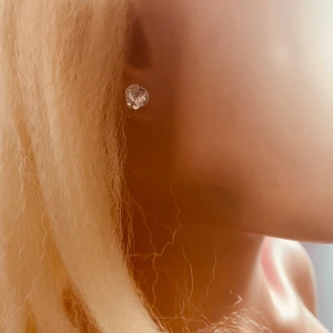 By prisförslag- 1 st Klassiskt diamant örhänge - 1 st stilrent örhänge med rund, gnistrande sten i silverfärg. Perfekt för dig som gillar en enkel men ändå glittrig look. Stenen är infattade i klassisk fattning och sitter tätt mot örat för en clean vibe.